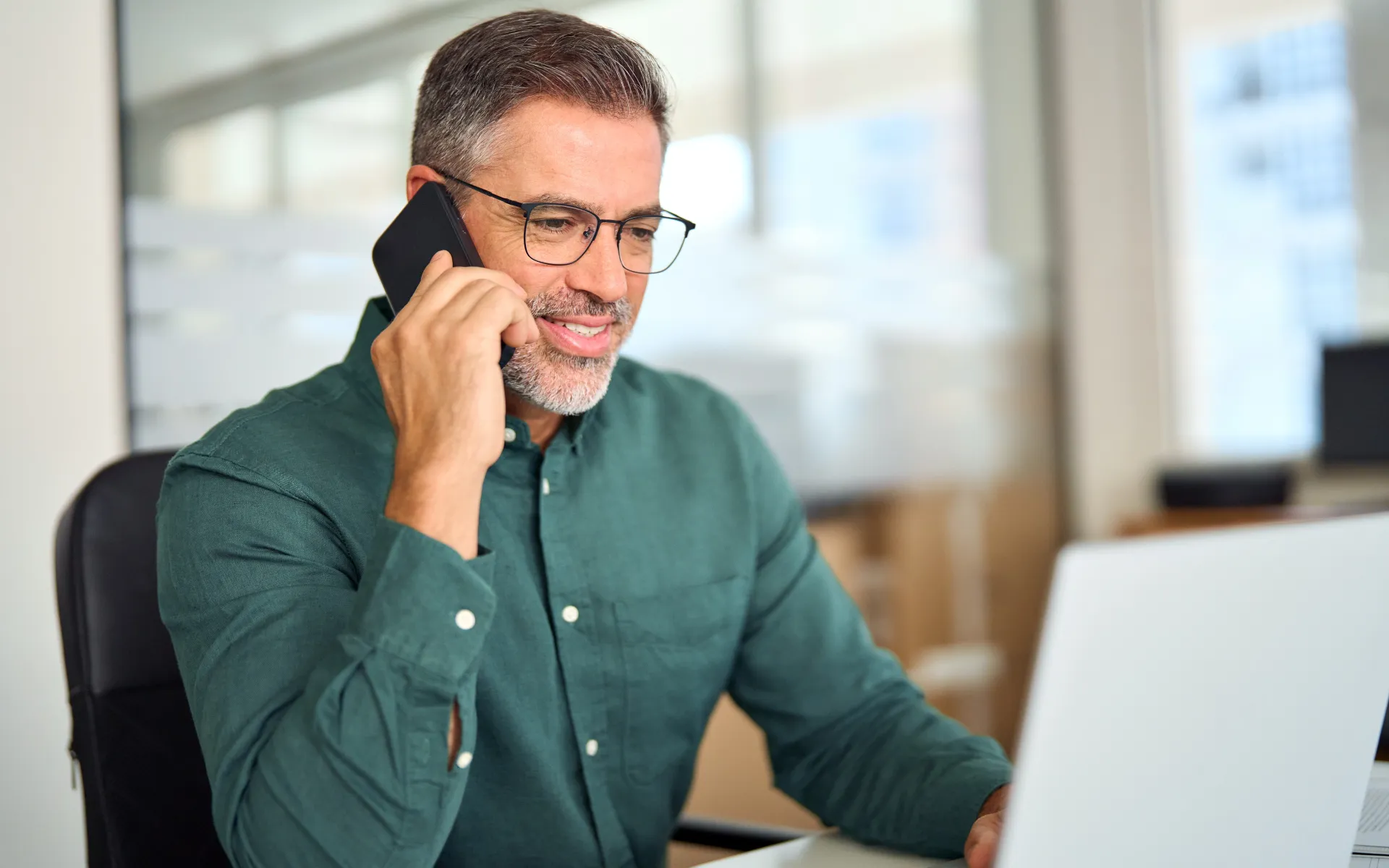 Man at computer making phone call